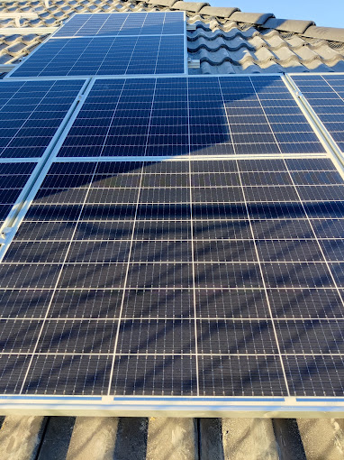 Einige Solarpanels sind auf einem Dach mit Wellblechdach installiert.